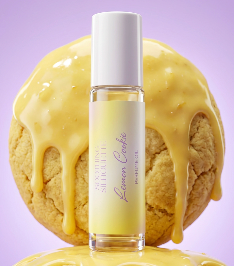 Lemon Cookie 10 milliliter perfume oil bottle.  Two large lemon cookies with lemon icing as photo props on a light purple background. Original Price: $14. Comes in a roll-on glass bottle. Notes are lemon, sugar cookie and vanilla. Ingredients are Isopropyl Myristate and Fragrance