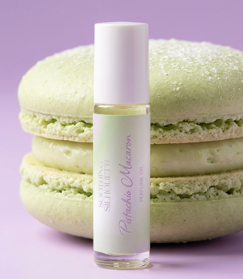 Pistachio Macaron 10 milliliter perfume oil bottle.  A large green pistachio macaron as a photo prop on a light purple background. Original Price: $14. Comes in a roll-on glass bottle. Notes are sugared pistachio, amaretto and buttery cookies.
Ingredients are Prunus Armeniaca (Apricot) Kernel Oil, Fragrance, Polycitronellol