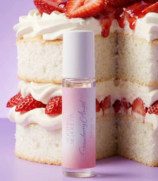 Strawberry Angel 10 milliliter perfume oil bottle.  A large strawberry angel food cake as a photo prop on a light purple background. Original Price: $14. Comes in a roll-on glass bottle. Notes are strawberry jam, angel food cake and vanilla. Ingredients are Isopropyl Myristate and Fragrance